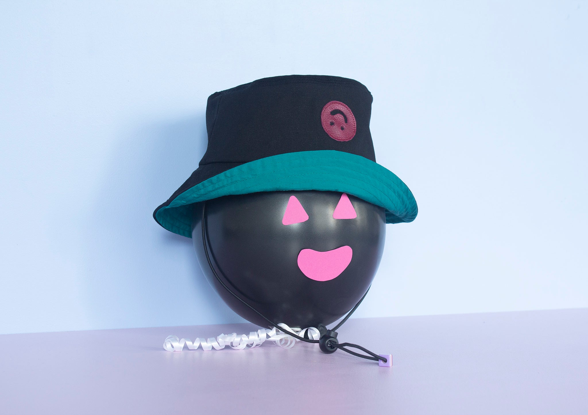 Bucket Hat noir appliqué Smiley mauve, doublure sarcelle
